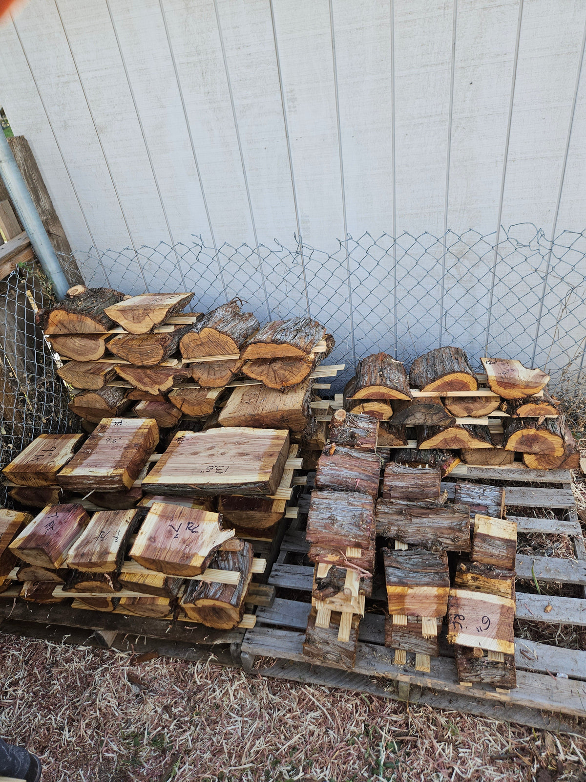 Lathe wood planks and lumber outdoors with tractor in background